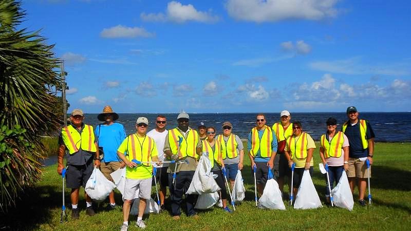 Adopt A Trail program participants posing together in reflective safety vests
